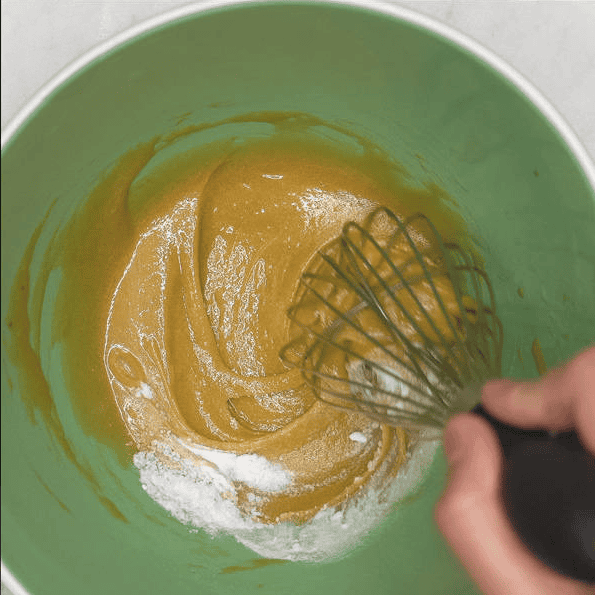 Mixing baking soda into the wet ingredients.