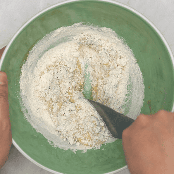 Mixing flour into the wet ingredients.