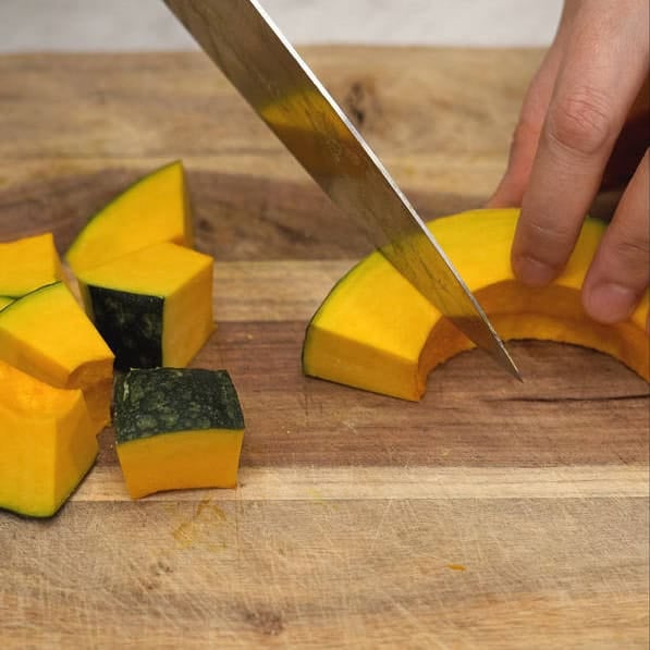 Slicing kabocha squash into cubes and into thin match sticks.