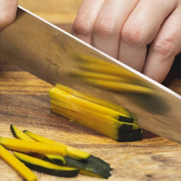 Slicing kabocha squash into cubes and into thin match sticks.