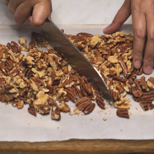 Chopping nuts and pineapple.