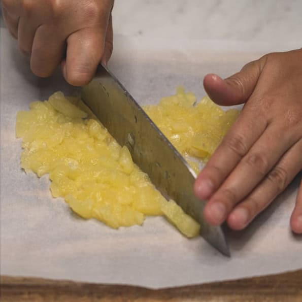 Chopping nuts and pineapple.