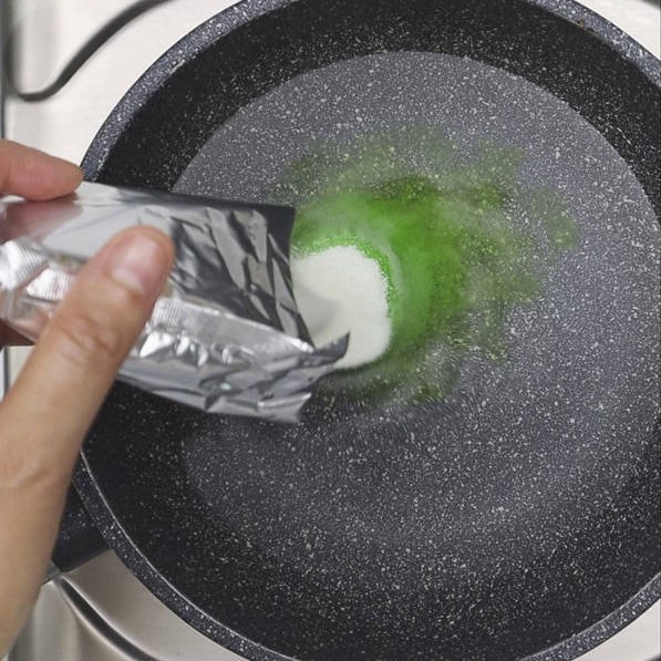 Adding agar-agar powder to the water in a saucepan. Boiling agar-agar and pandan leaves in a saucepan.