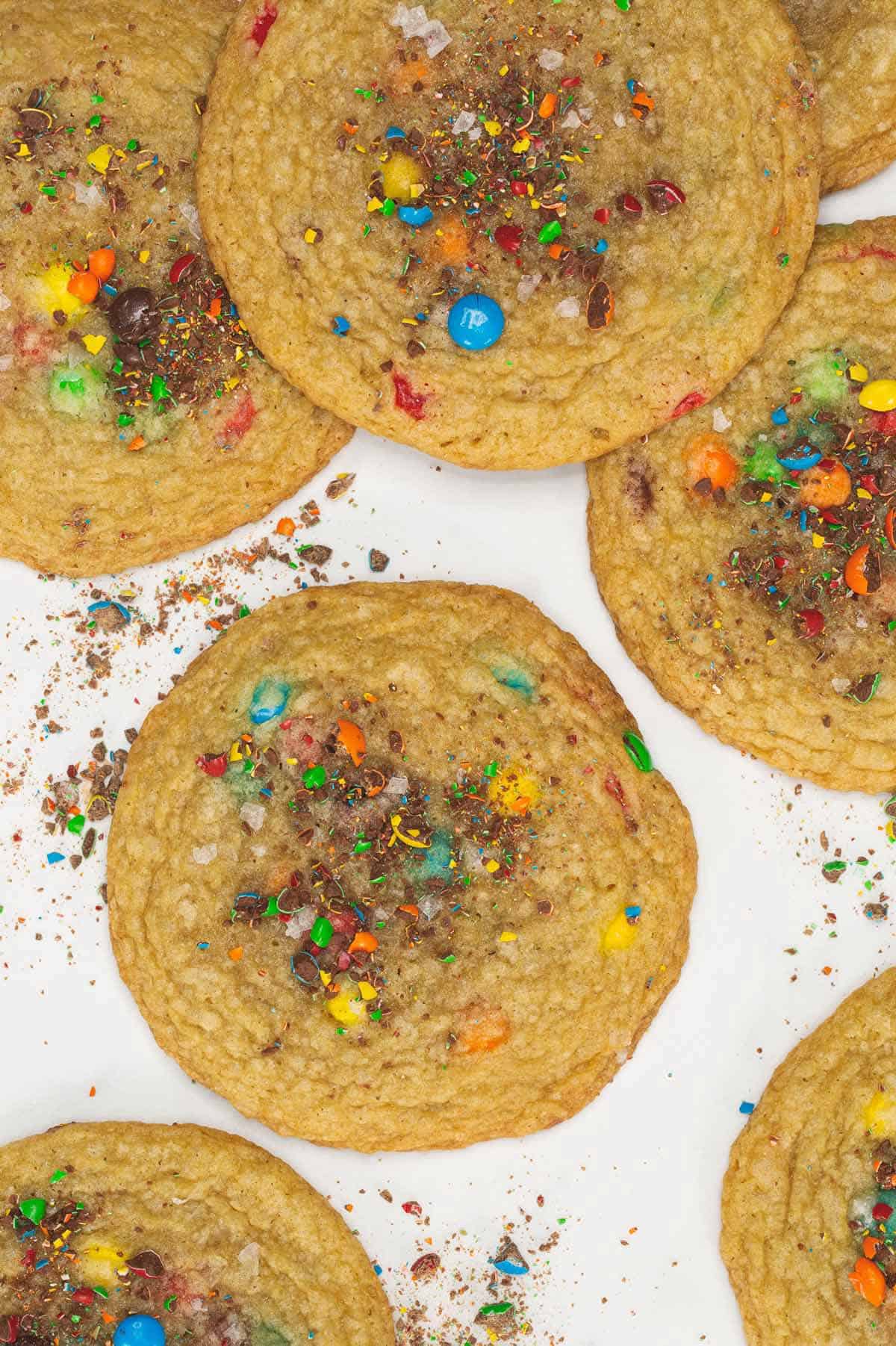 Baked M&M cookies on a parchment paper.
