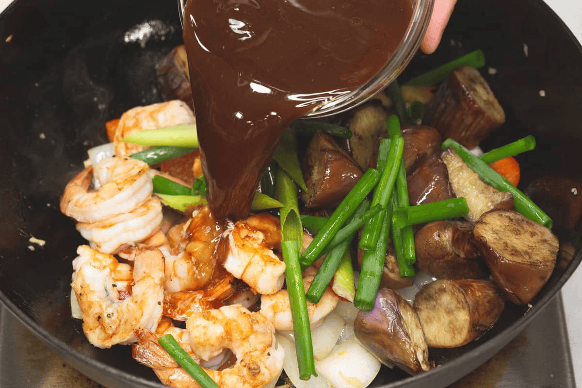 Pouring the sauce into the wok.