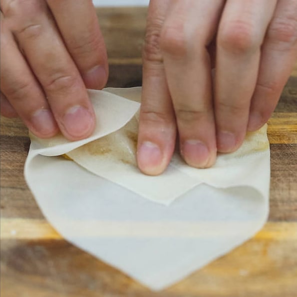 Banana slice and jackfruit strips on a spring roll wrapper. Folding the sides of a spring roll wrapper.