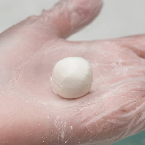 Mixing the dough and forming small balls, using your hands.