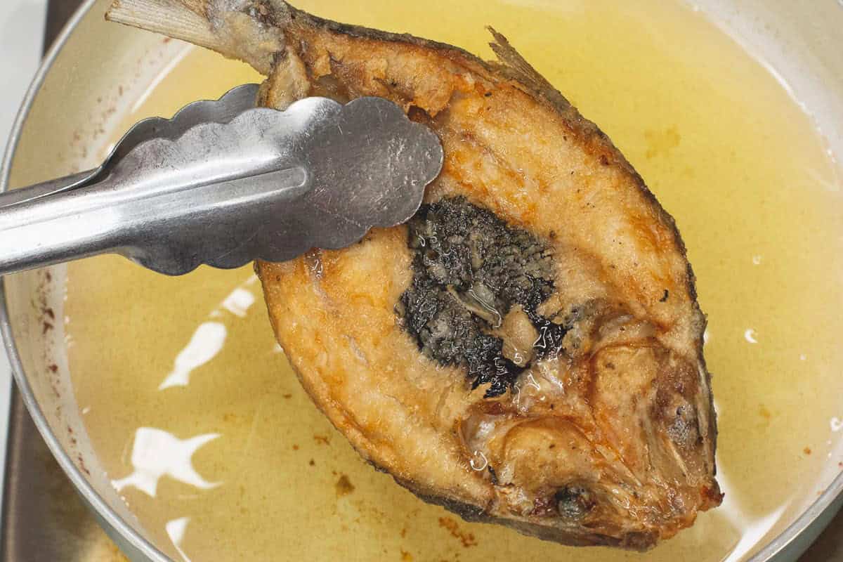 Taking the fried bangus out of the oil.