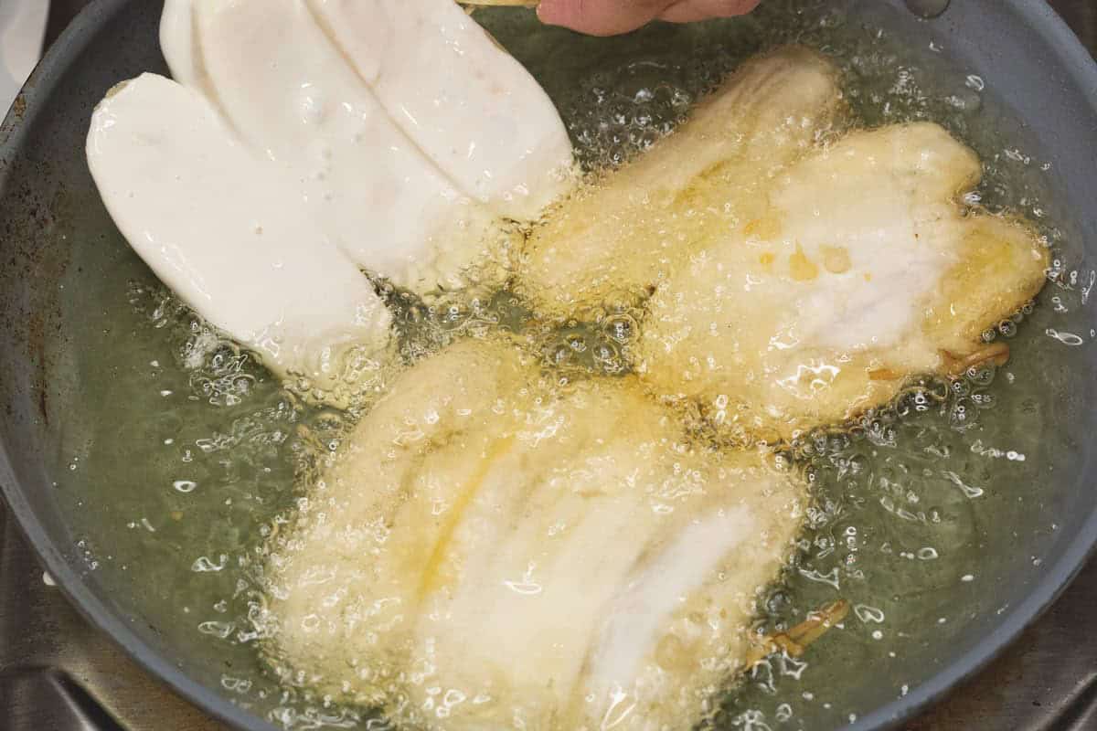 Frying saba banana fritters in oil.