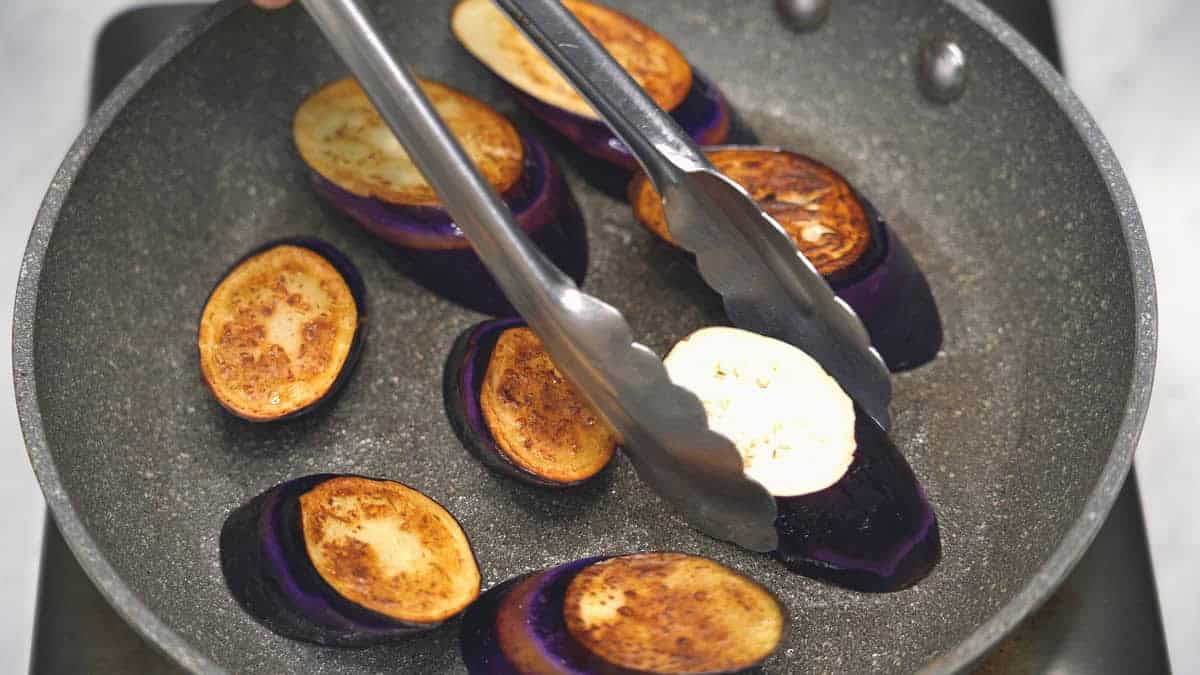 Frying the eggplant in a skillet.