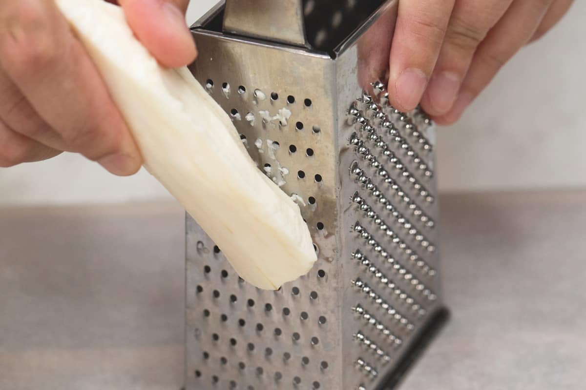 Grating cassava on a box grater.