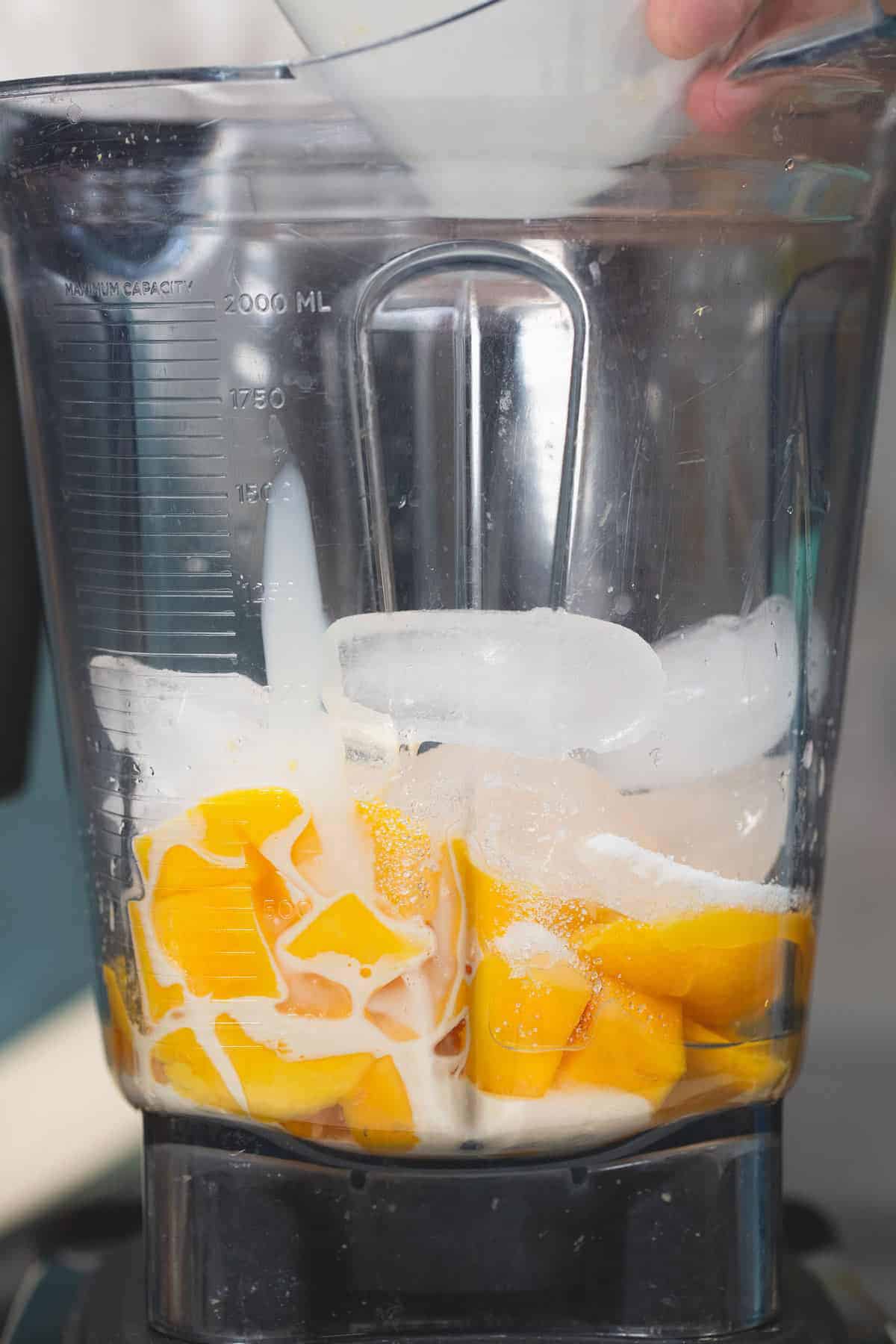 Mango shake ingredients in a blender.