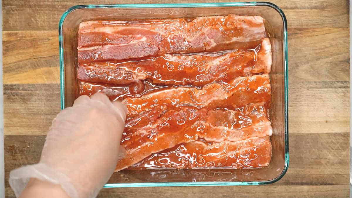 Marinating the pork belly slices in the mixture.