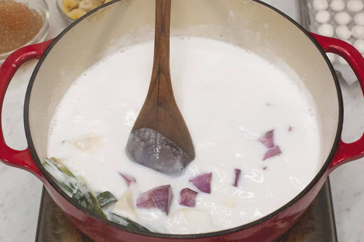 Mixing the coconut mixture with cassava and purple sweet potatoes.