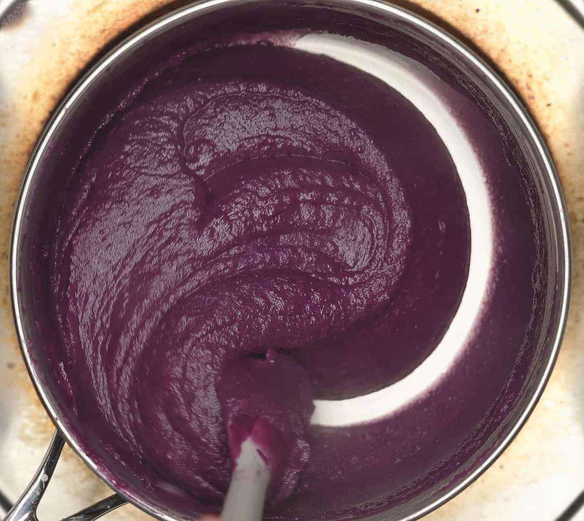 Mixing the thickened ingredients for Ube Halaya (Purple Yam Jam) in a saucepan.