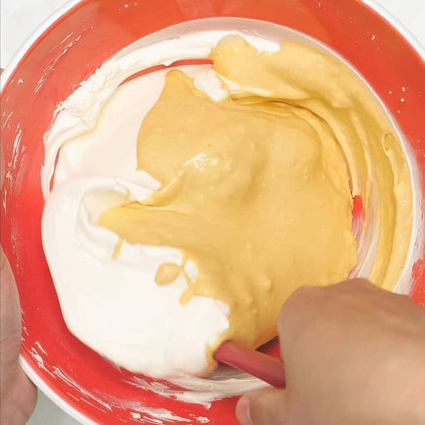 Folding in a portion of the mascarpone mixture to the zabaglione in the bowl. Mixing the remaining mascarpone mixture and the zabaglione in the bowl.