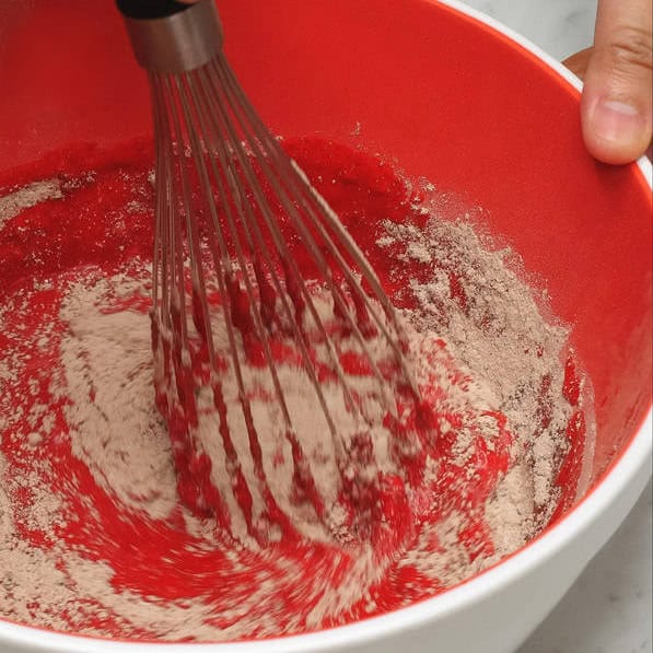 Mixing the dry and wet ingredients in the bowl. Adding the dry ingredients to the wet ingredients in the bowl.