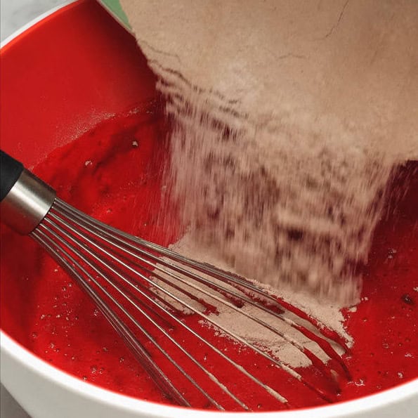 Mixing the dry and wet ingredients in the bowl. Adding the dry ingredients to the wet ingredients in the bowl.