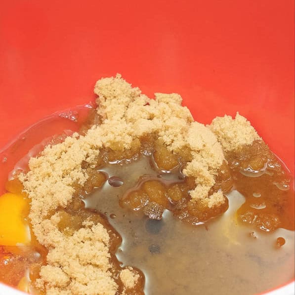 Combining the wet ingredients in a bowl. Mixing the wet ingredients using a whisk.