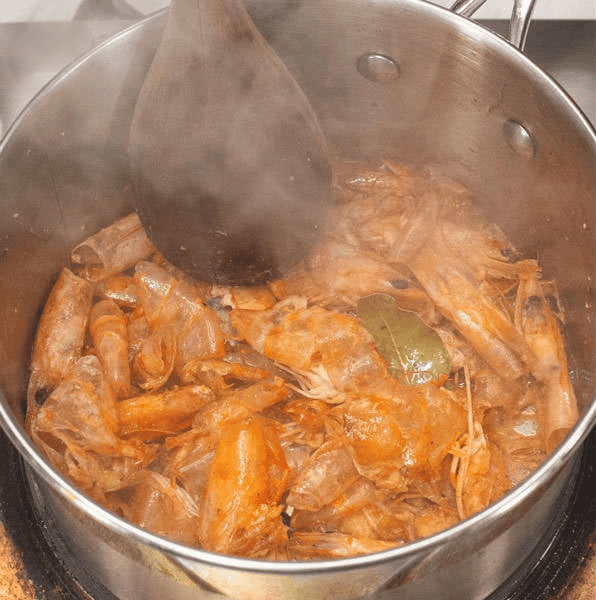 Browning shrimp heads and shells in a pot.