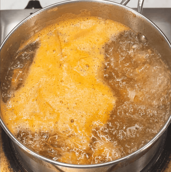 Simmering shrimp stock in a pot.