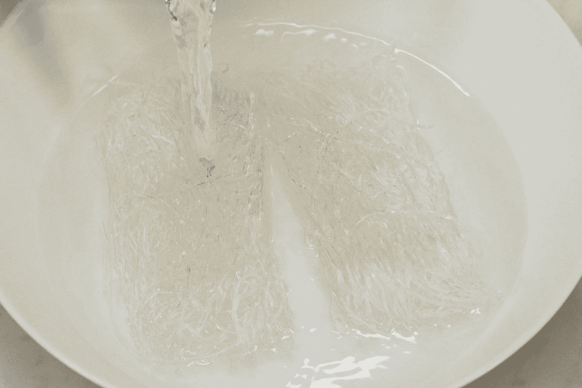 Adding water to soak the sotanghon in a bowl.