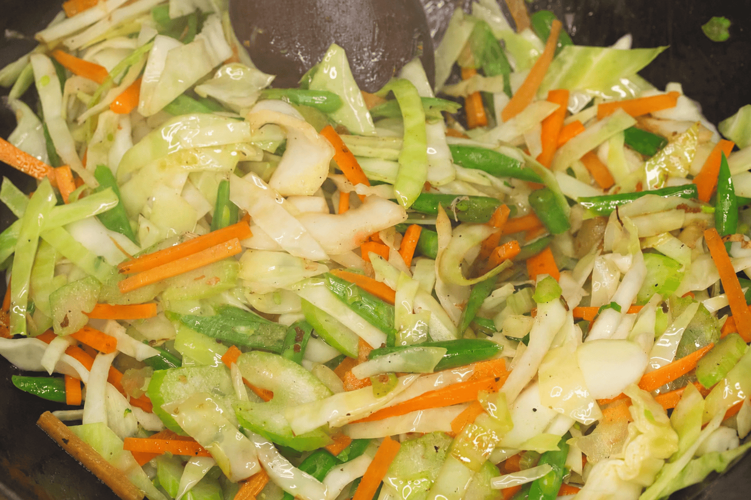 Stir-frying the vegetables in the wok.