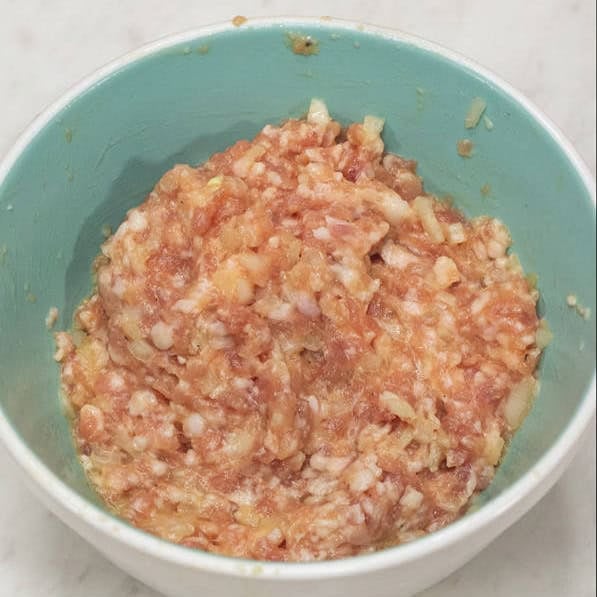 Ground meat mixture in a bowl and straining the fried meatballs in a skimmer over the saucepan.