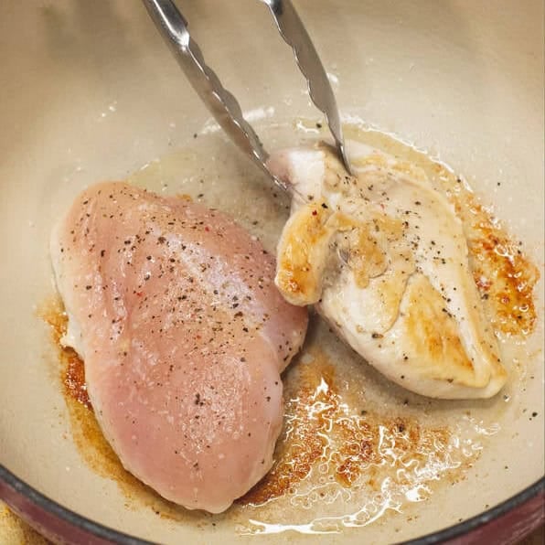 Searing the chicken breasts, then shredding them.