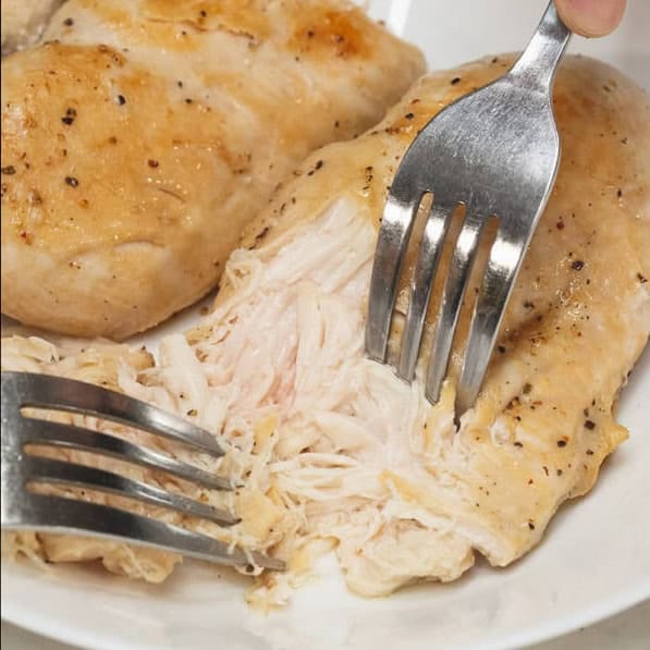Searing the chicken breasts, then shredding them.