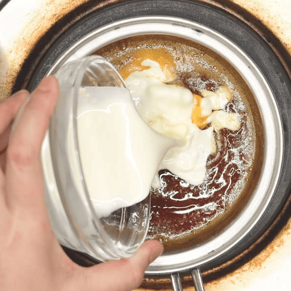 Pouring cream into the caramel sauce.