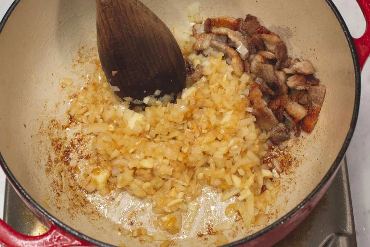 Sauteing the aromatics with the browned pork on the side.