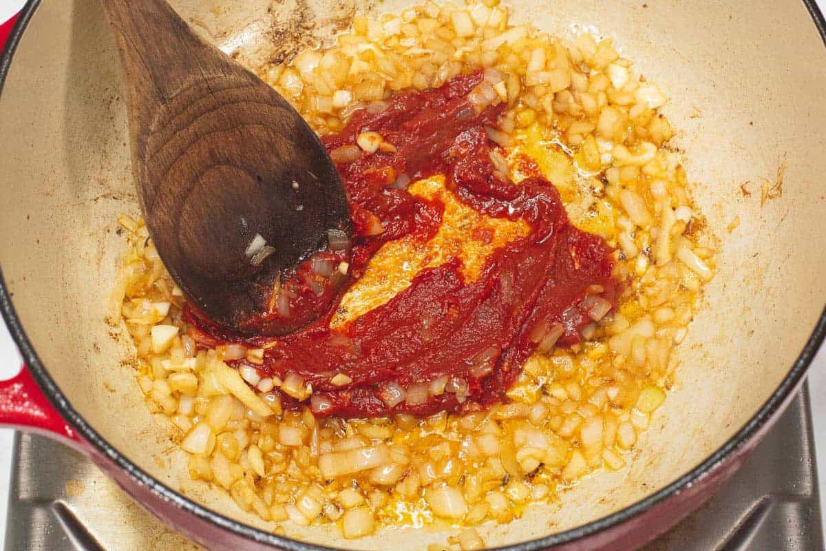 Sauteing tomato paste with aromatics.