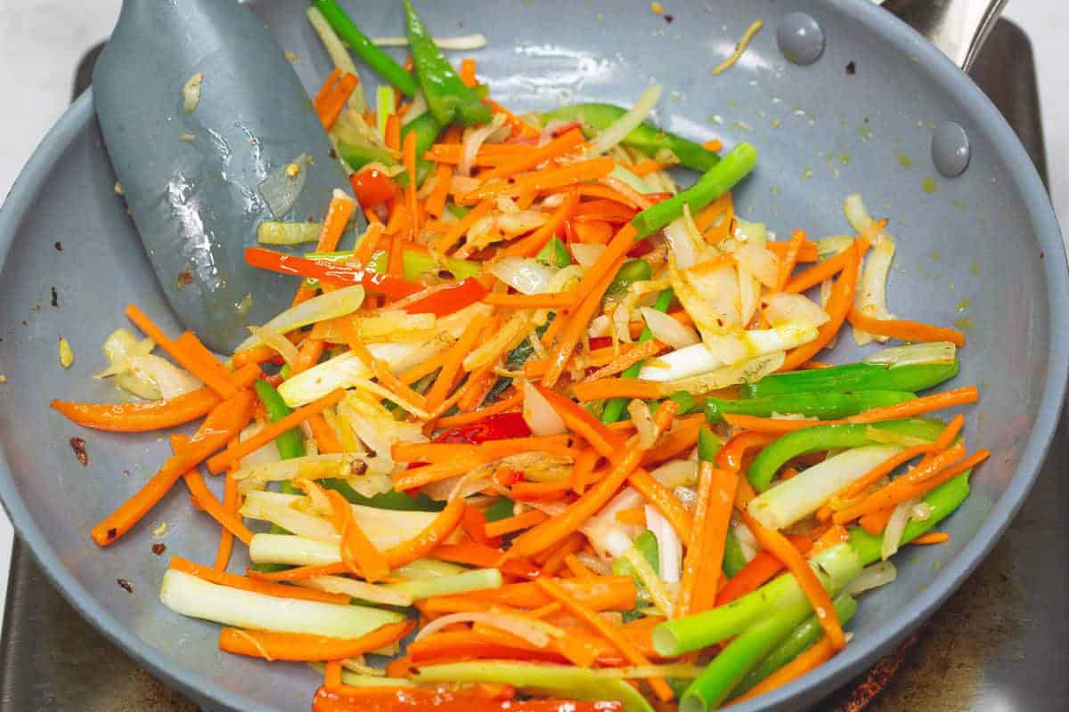Sauteing aromatics and vegetables in a skillet.