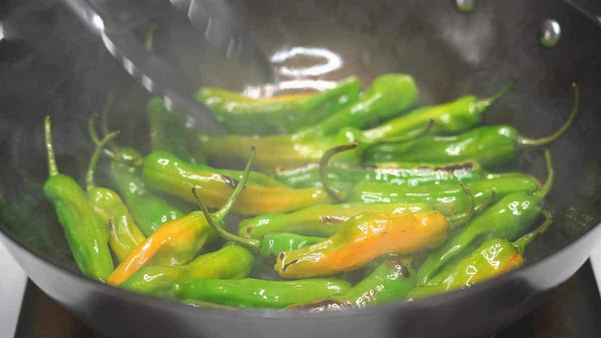 Shishito peppers in the hot wok.