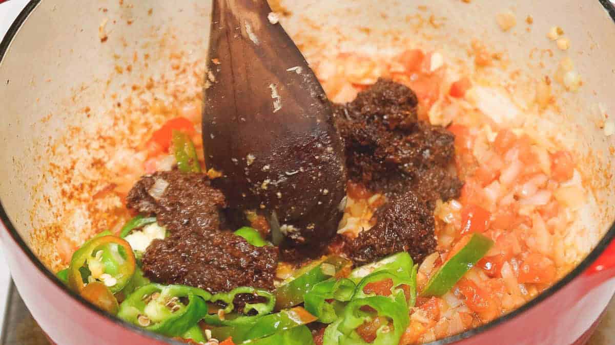 Shrimp paste and chili peppers added to the aromatics in the pot.