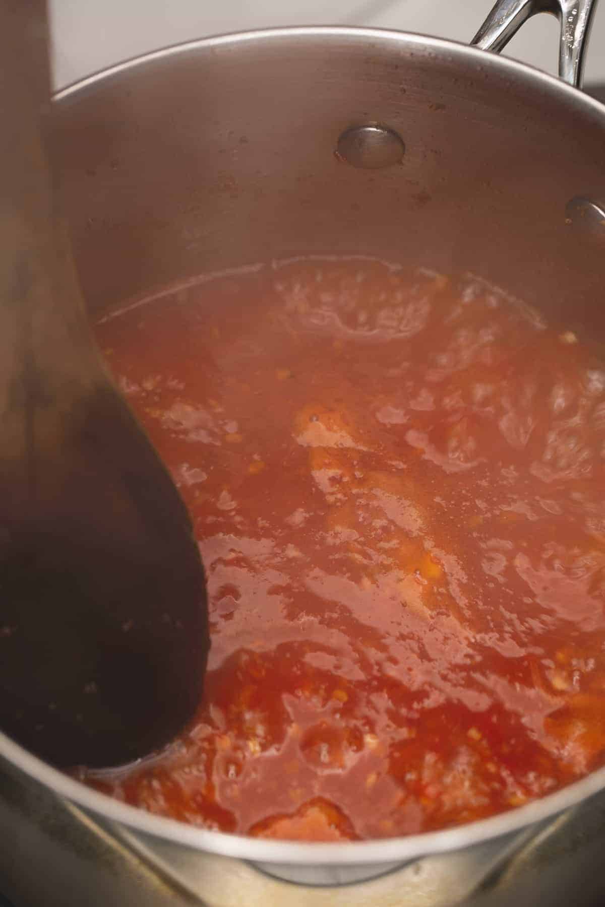 Sweet chili sauce simmering in a saucepan.