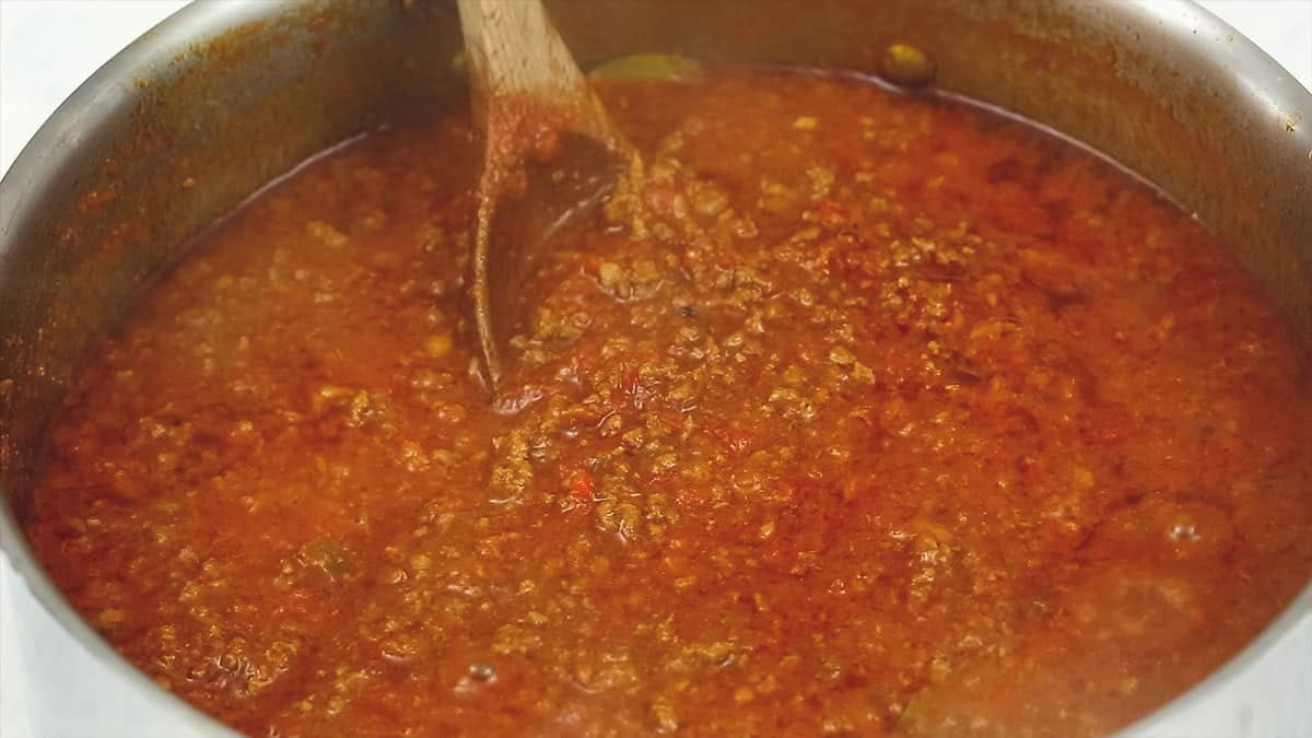Simmering the meat sauce in the pan.