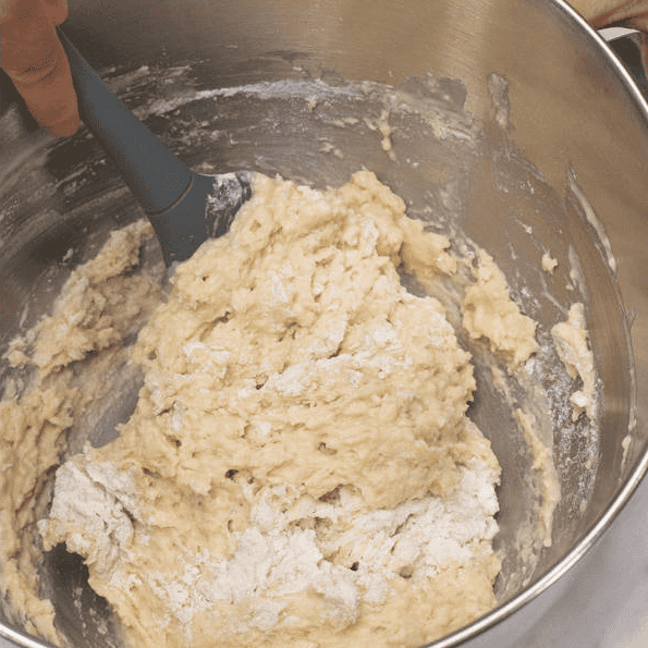 Mixing the wet and dry ingredients into a rough dough.