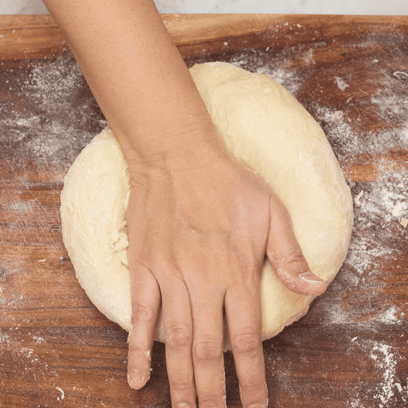 Pushing the dough with the heel of the hand.