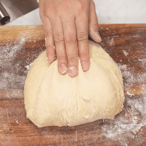 Folding the dough while kneading by hand.