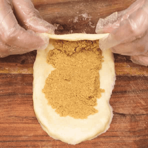 Folding the top edge of dough over the filling.