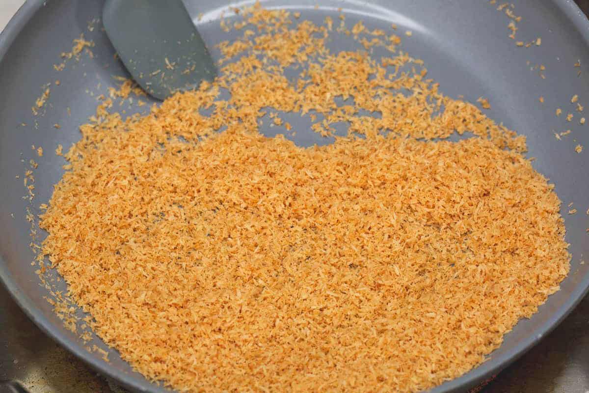 Stirring the browned coconut in the pan.