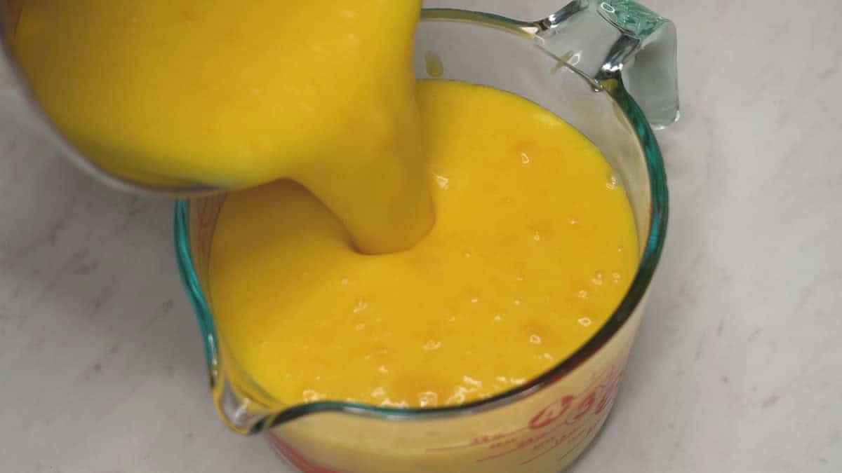 Pouring the thickened ice cream mixture into a container.