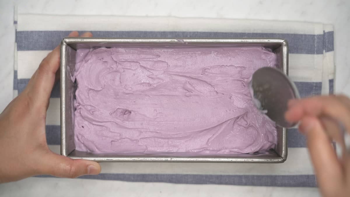 Spreading the churned ice cream in a loaf pan.
