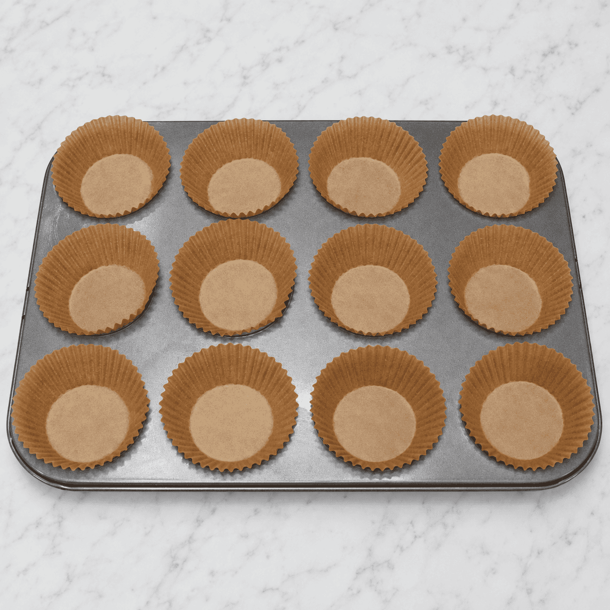 Lining the muffin pan with cupcake liners.