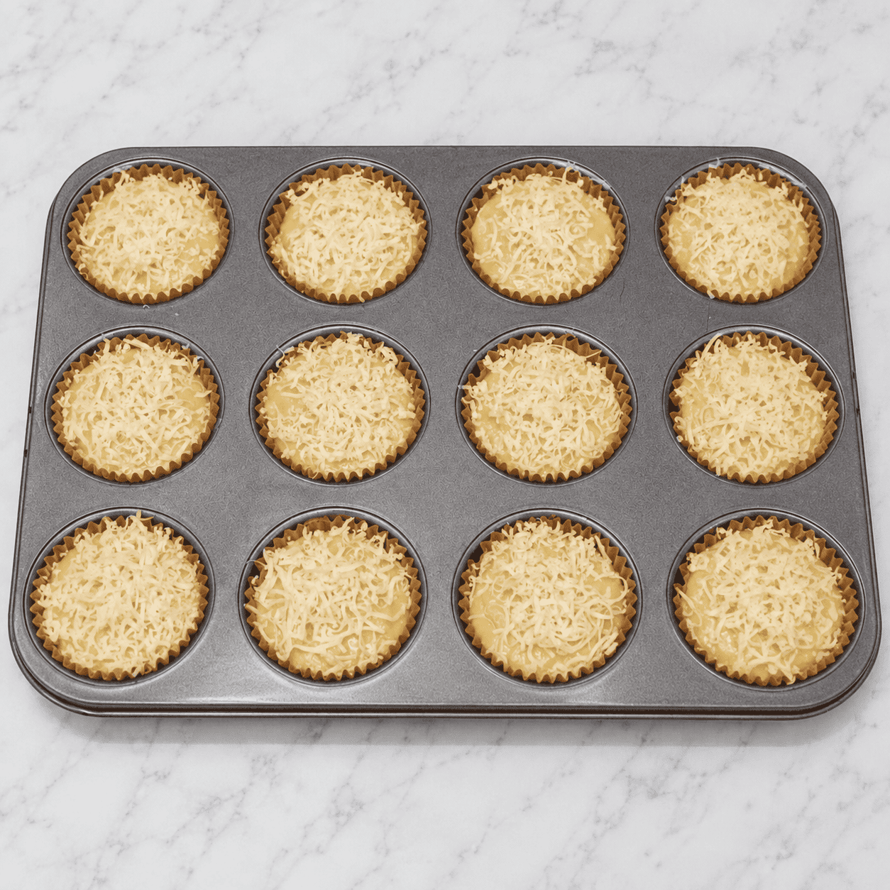 Filled the liners with the cupcake batter, then topped them with cheese.